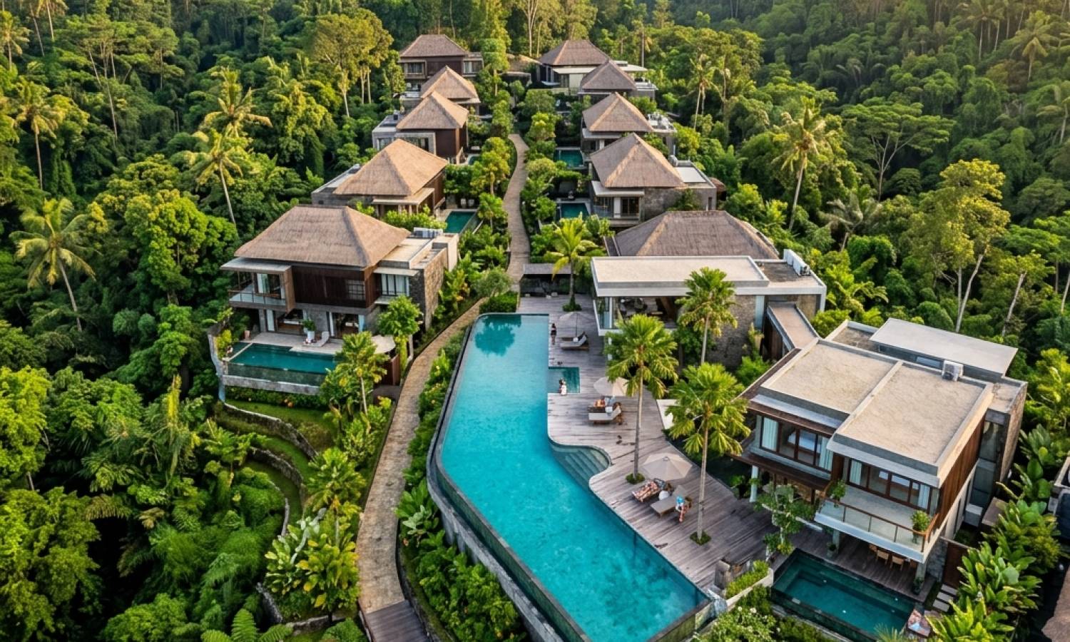 A bird's-eye view of modern luxury villas surrounded by lush tropical nature in Bali.